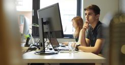 Mitarbeiter arbeiten an Computer Arbeitsplätzen in der Digital Agentur.