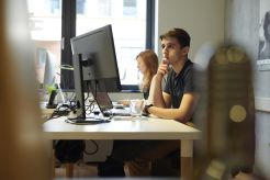 Mitarbeiter arbeiten an Computer Arbeitsplätzen in der Digital Agentur.